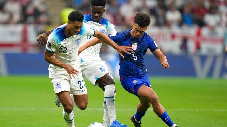 England's Jude Bellingham, left, challenges for the ball with Antonee Robinson of the United States, right, during the World Cup group B soccer match between England and The United States, at the Al Bayt Stadium in Al Khor, Qatar, Friday, Nov. 25, 2022. (AP Photo/Andre Penner)
