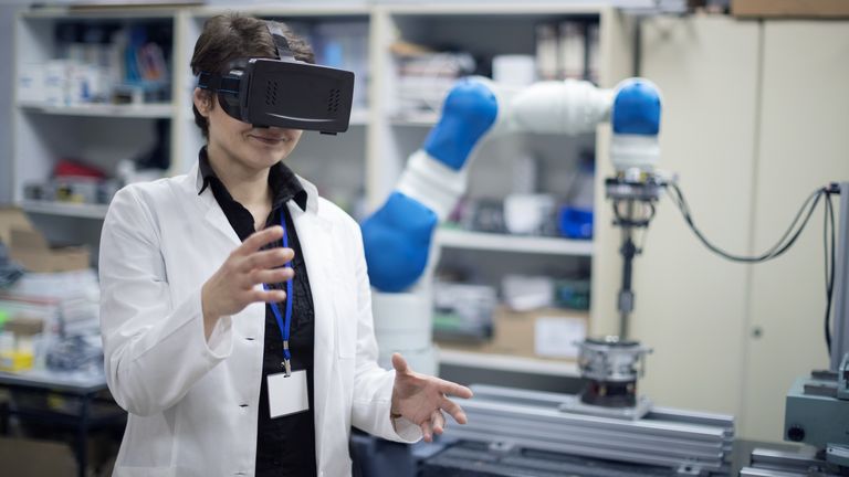 Woman trying virtual reality simulator glasses in research lab