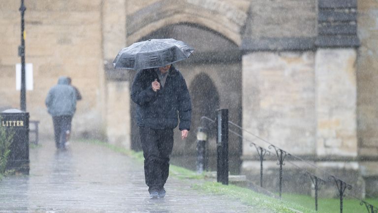 A man shelters under an umbrella as he walks in the rain near Wells Cathedral, Wells, Somerset. 