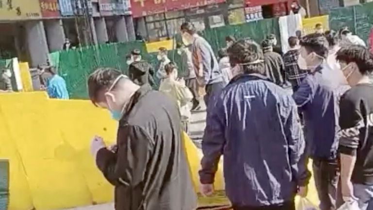 A screenshot taken from a video posted on Nov. 23, 2022 shows a group of people walking through a collapsed fence after a protest at a Foxconn factory in Zhengzhou, China. Video courtesy of Reuters/via Reuters. This image was provided by a third party. Resale prohibited.no file