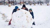 Sal Wood, Blake Wood and Jacobi Wood, 6, roll the largest snowball at Camel&#39;s Back Park in Boise, Idaho, on Monday, Dec. 12, 2022, after 2.5 inches of snow fell overnight according to the National Weather Service. No more snow is in the forecast for the Boise area this week, but temperatures are expected to drop to as low as 6 degrees by Saturday night. (Sarah A. Miller/Idaho Statesman via AP)