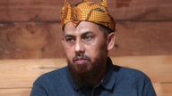 Indonesian militant Umar Patek pauses during his visit at the house of his long-time friend Ali Fauzi