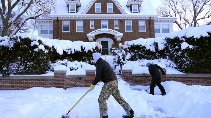 Kids shovel snow off a sidewalk and driveway in Minneapolis
PIC:AP