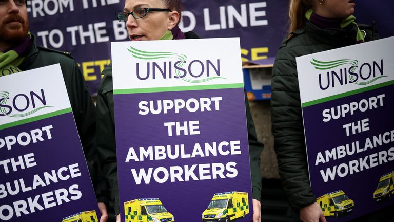 Ambulance workers holds signs as they take part in a strike, amid a dispute with the government over pay, outside NHS London Ambulance Service in London, Britain December 21, 2022. REUTERS/Henry Nicholls
