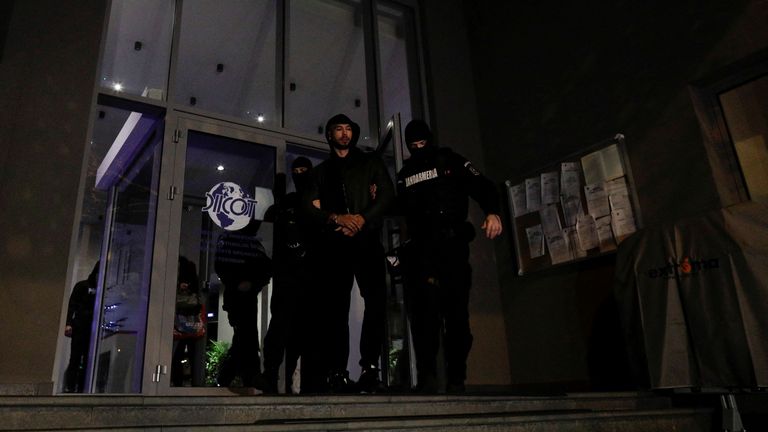 Andrew Tate is escorted by police officers outside the headquarters of the Directorate for Investigating Organized Crime and Terrorism in Bucharest (DIICOT) after being detained for 24 hours, in Bucharest, Romania, December 29, 2022