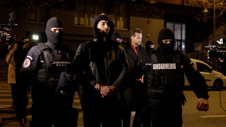 Andrew Tate and Tristan Tate are escorted by police officers outside the headquarters of the Directorate for Investigating Organized Crime and Terrorism in Bucharest (DIICOT) after being detained for 24 hours, in Bucharest