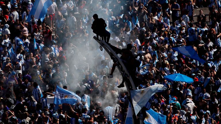 Argentina fans are pictured climbing street lights as they celebrate winning