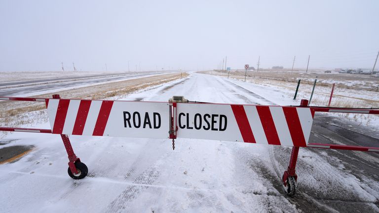 A closed sign hangs over a closed gate to prevent traffic from entering the eastbound lane of Interstate 70 on East Airpark Road, Tuesday, Dec. 12.  13, 2022, Aurora, Colorado. A massive winter storm has closed roads in northeastern Colorado.  (AP Photo/David Zarubowski)