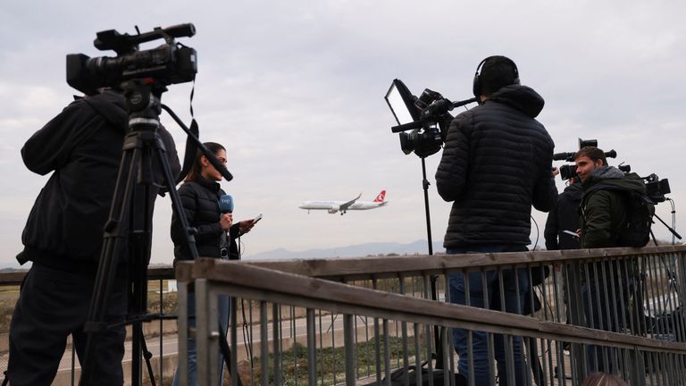 Wartawan berkumpul setelah pesawat komersial yang terbang dari Maroko ke Turki melakukan pendaratan darurat di bandara El Prat Barcelona pada dini hari dan 28 calon migran di dalamnya melarikan diri ke landasan Barcelona, ​​di Spanyol, 7 Desember 2022. REUTERS/Nacho Doce ULANG - ULANGI KUALITAS