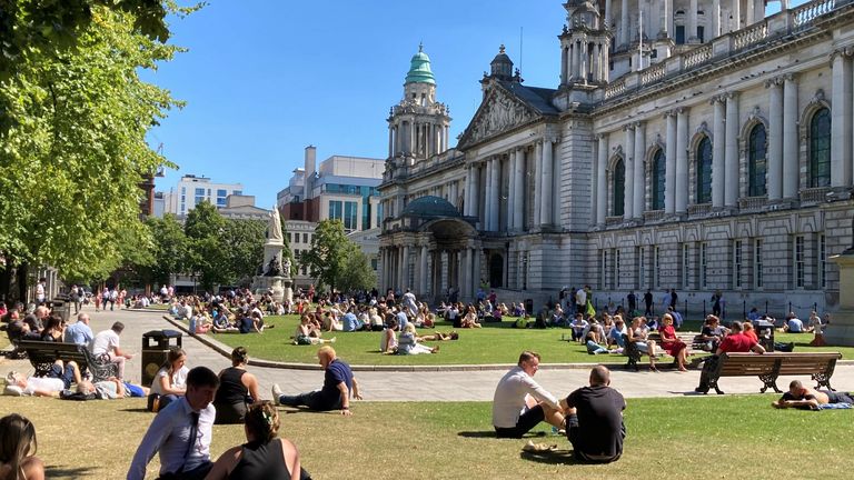 People in the grounds of Belfast City Hall watch Queen Elizabeth II funeral on a large screen. Picture date: Monday September 19, 2022.
