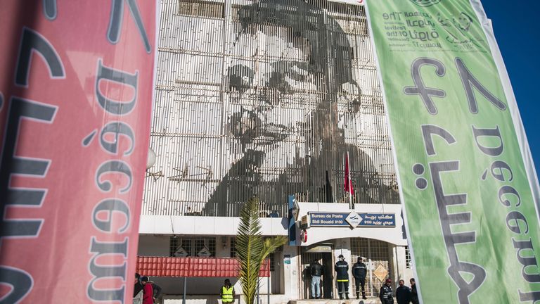 An image of Mohammed Bouazizi is depicted on the facade of the post office building, in Sidi Bouzid, Tunisia, Friday, December 17, 2021. 