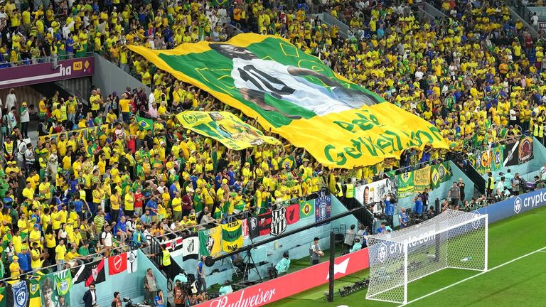 A large flag with former Brazilian player Pele saying 'Get well soon' is displayed by fans