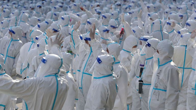 Medical workers in protective suits wave at Changchun residents during a farewell ceremony before returning to Meihekou, where they were dispatched from to help curb the coronavirus disease (COVID-19) outbreak in Changchun, Jilin province, China April 12, 2022. Picture taken April 12, 2022. China Daily via REUTERS ATTENTION EDITORS - THIS IMAGE WAS PROVIDED BY A THIRD PARTY. CHINA OUT. TPX IMAGES OF THE DAY
