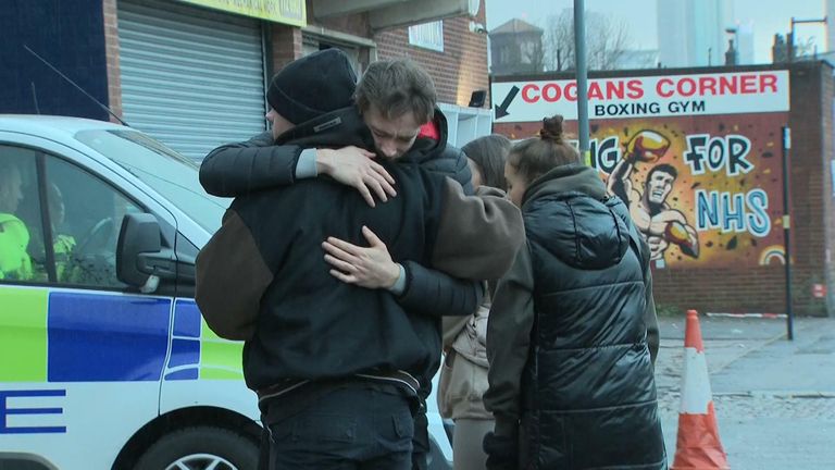 Cody Fisher&#39;s friends hug after laying flowers outside the nightclub where he died.
