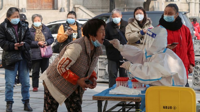 Çin'in Hubei eyaleti, Wuhan'da hükümet koronavirüs hastalığı (COVID-19) kontrolündeki kısıtlamaları hafiflettikten sonra, bir tıp çalışanı nükleik asit testi için bir sakinden sürüntü örneği alıyor 10 Aralık 2022. REUTERS/Martin Pollard