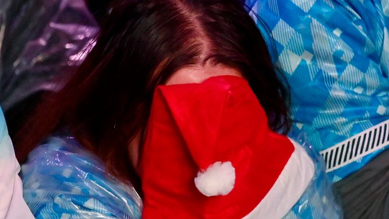 A fan in London covers her face with a Christmas hat as England's World Cup hopes are dashed 