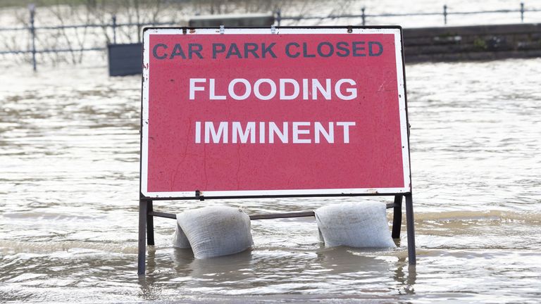 A flood warning sign at the entrance to a flooded car park in Whitesands, Dumfries