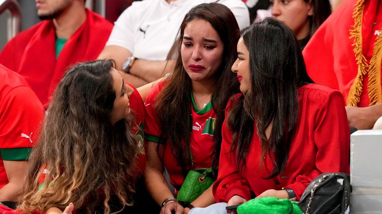 A Morocco fan is comforted in the stands