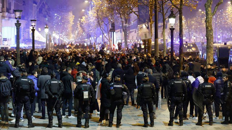Police officers in riot gear are pictured as France fans celebrate on the Champs-Elysees