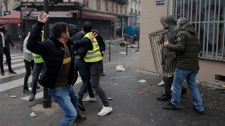 A demonstrator throw a stone during a protest against the recent shooting at the Kurdish culture center in Paris, Saturday, Dec. 24, 2022. Kurdish activists, left-wing politicians and anti-racism groups are holding a protest Saturday in Paris after three people were killed at a Kurdish cultural center in an attack aimed at foreigners.(AP Photo/Lewis Joly)