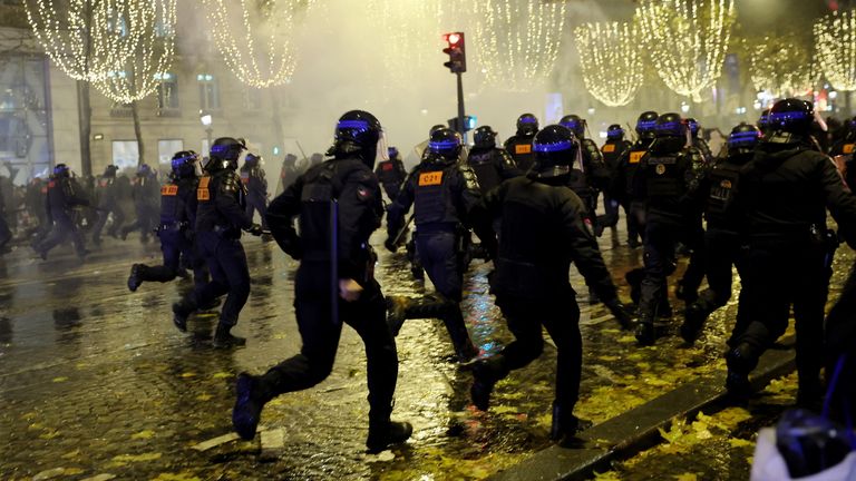 French police react to fans on the Champs-Elysees during the final between France and Argentina