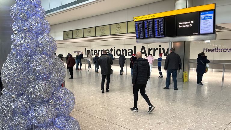 People wait in the arrivals hall at terminal 5 of Heathrow airport