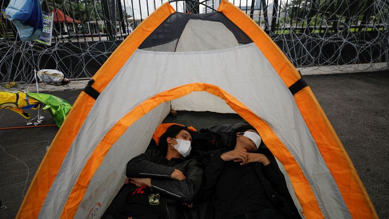 Activists lie inside a tent during a protest after Indonesia&#39;s parliament banned extramarital sex.