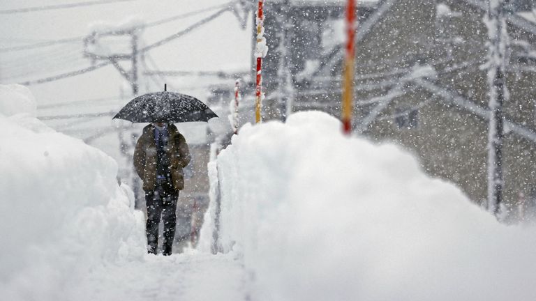 A man makes his way in the heavy snow in Uonuma, Niigata Prefecture. Pic: Reuters