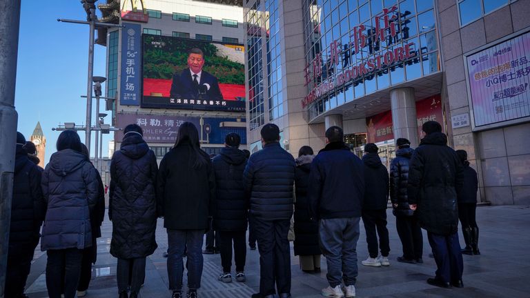 People in Beijing watch a live broadcast of the memorial service for late former Chinese President Jiang Zemin. Pic: AP