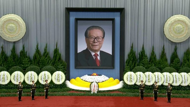 Guards stand near a giant portrait of late former Chinese President Jiang Zemin during a formal memorial held at the Great Hall of the People in Beijing. Pic: AP