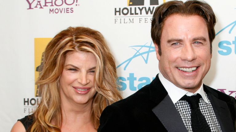 Actor John Travolta (C) holds his Supporting Actor award he received with presenter actress Kirstie Alley (L) and his wife actress Kelly Preston (R) backstage at the Hollywood Awards gala held by the Hollywood Film Festival in Beverly Hills, California October 22, 2007. REUTERS/Fred Prouser (UNITED STATES)