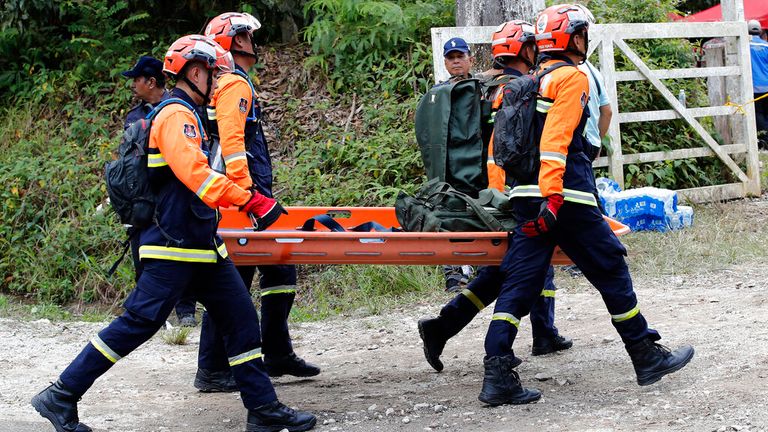 Rescue team prepare equipment near the site of a landslide at an organic farm in Batang Kali, Malaysia, Friday, Dec. 16, 2022.  Dozens of Malaysians were believed to have been at a tourist campground in Batang Kali, outside the capital of Kuala Lumpur, when the incident occurred, said a district police chief. (AP Photo/FL Wong)