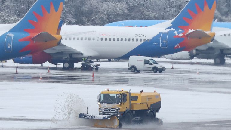A snow plough clears snow from the taxi ways at Manchester Airport, Manchester, Britain, December 10, 2022