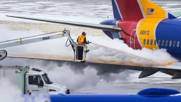 Crew members de-ice a Southwest Airlines plane before takeoff in Omaha, Nebraska, Wednesday, Dec. 21 Photo: AP