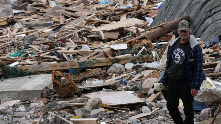 A person carrying a teddy bear walks along the coast in the aftermath of Hurricane Fiona in Port aux Basques, Newfoundland, Canada September 26, 2022. REUTERS/John Morris