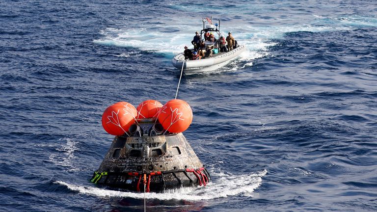 AT SEA, PACIFIC OCEAN - DECEMBER 11: NASA&#39;s Orion Capsule is drawn to the well deck of the U.S.S. Portland after it splashed down following a successful uncrewed Artemis I Moon Mission on December 11, 2022 seen from aboard the U.S.S. Portland in the Pacific Ocean off the coast of Baja California, Mexico. A 26-day mission took the Orion spacecraft to the moon and back which completed a historic test flight that coincided with the 50th anniversary of the landing of Apollo 17 on the moon, the last 