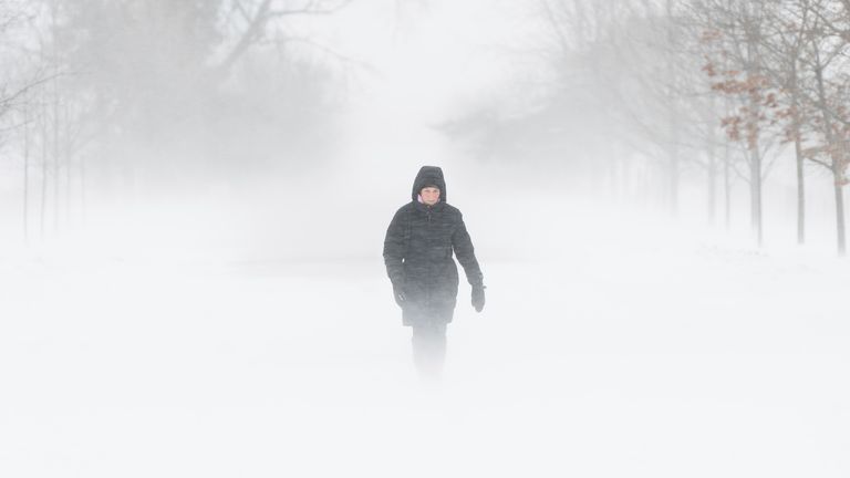 A person walks through the Central Experimental Farm during high winds and snow squalls in Ottawa, Canada, Saturday, Dec. 24, 2022. Photo: AP