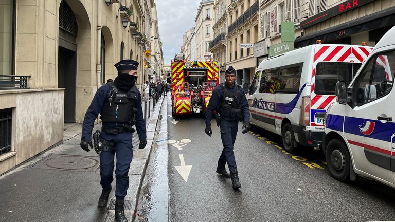 French police and firefighters secure a street after gunshots were fired killing two people and injuring several in Paris