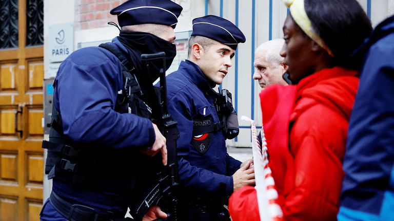 French police talk to people as they secure a street after shots were fired killing two people and injuring several in a central district of Paris, France, December 23, 2022. REUTERS/Sarah Meyssonnier 