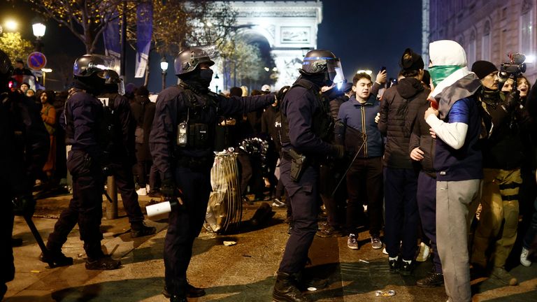 Soccer Football - FIFA World Cup Qatar 2022 - Fans gather in Paris for France v Morocco - Paris, France - December 14, 2022 Police officers in riot gear are pictured as France fans celebrate on the Champs-Elysees after the match REUTERS/Benoit Tessier