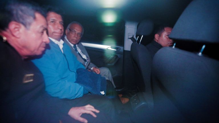 追放されたペドロ・カスティージョ大統領 (写真は青いシャツを着ている) が警察署を出た後、車の中で座っている