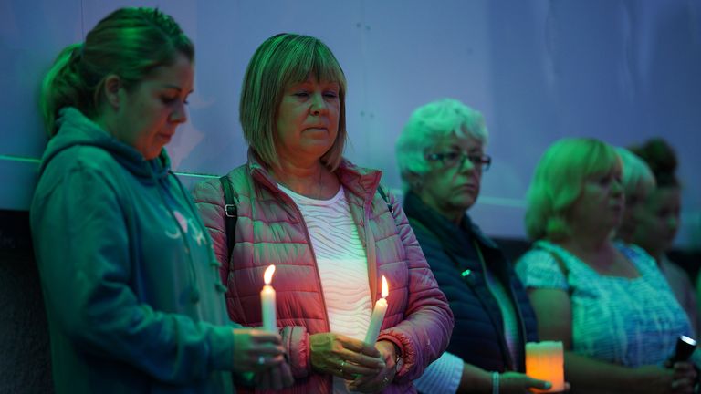 Members of the public hold candles while attending a vigil for the community in Plymouth August 2021