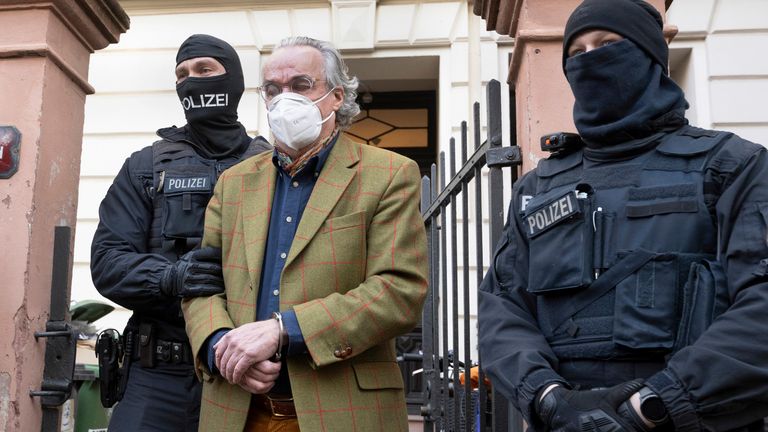 Police officers lead Prince Reuss  to a police vehicle after searches at a house 
PIC:DPA/AP