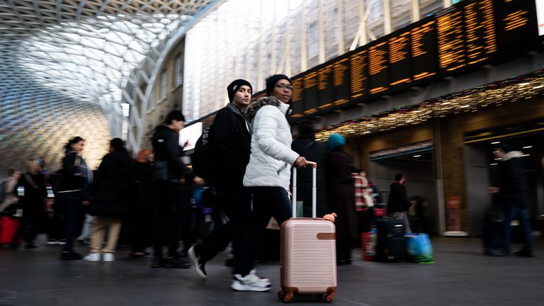 People prepare to board trains at Kings Cross Station in London during a strike by members of the Rail, Maritime and Transport union (RMT), in a long-running dispute over jobs and pensions