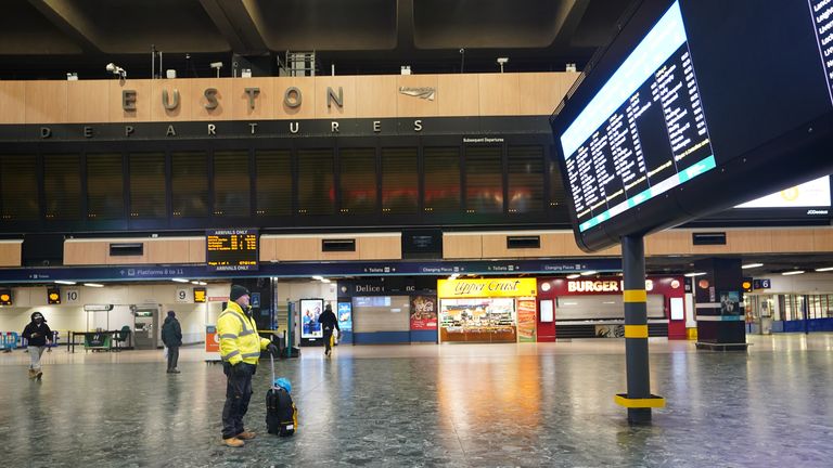 A man looks at the departures board at Euston train station in London during a strike by members of the Rail, Maritime and Transport union 