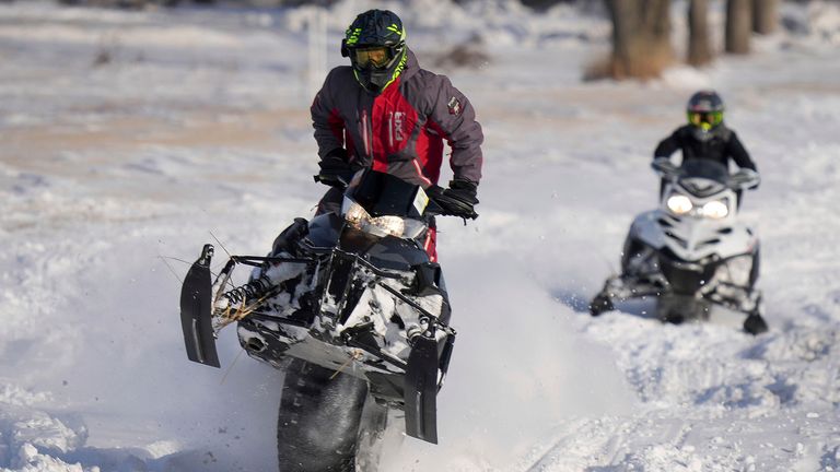 Rob Keeling of Cambridge, Iowa, catches some air on his snowmobile as his son, Blake, 13, rides behind in a ditch near Huxley, Iowa,
The Des Moines Register/AP