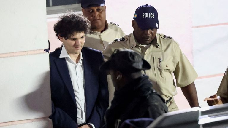 Sam Bankman-Fried est escorté hors du tribunal à Nassau, aux Bahamas