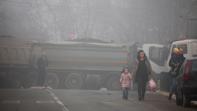 Local Serbs walk near a roadblock, near the northern part of the ethnically-divided town of Mitrovica, Kosovo