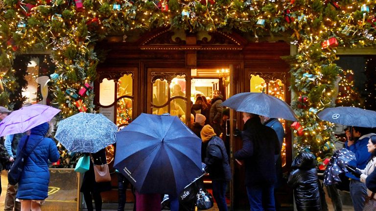 Shoppers queue to enter a Fortnum and Masons store with Christmas decorations, in London, Britain, December 18, 2022. REUTERS/Toby Melville 