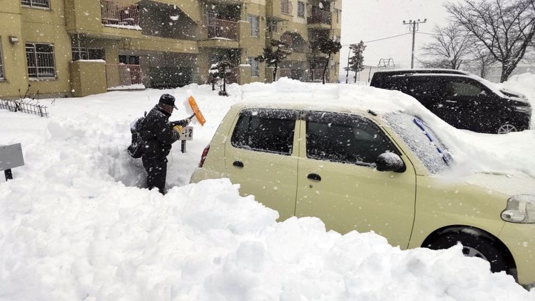 A man clears snow at a parking lot in Kitami, Hokkaido Prefecture, Japan